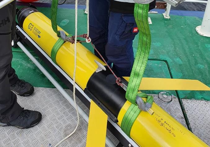 Sling positioned against the hull, aft of the wings